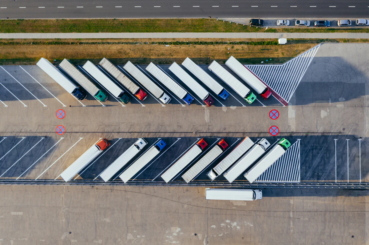 Fleet of freight trucks staged at a logistics depot, seen from above